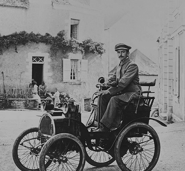 Fotografía en blanco y negro de un hombre sobre uno de los primeros coches de 2 cilindros Circa 1902