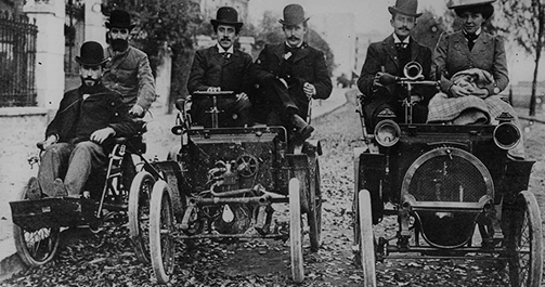 Fotografía en blanco y negro de un grupo de hombres sobre tres coches de 2 cilindros Circa 1902