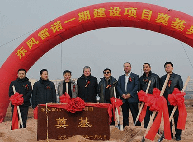 Grupo de personas asiáticas en una ceremonia de inauguración con textos en chino